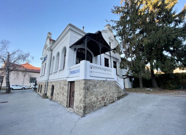 PREŠOV-ŠIRŠIE CENTRUM,POLYFUNKČNÁ BUDOVA,VL.PARKOVISKO,UL.VAJANSKÉHO - Budova na Vajanského ulici v Prešove s elegantným kamenným základom a bielou fasádou.