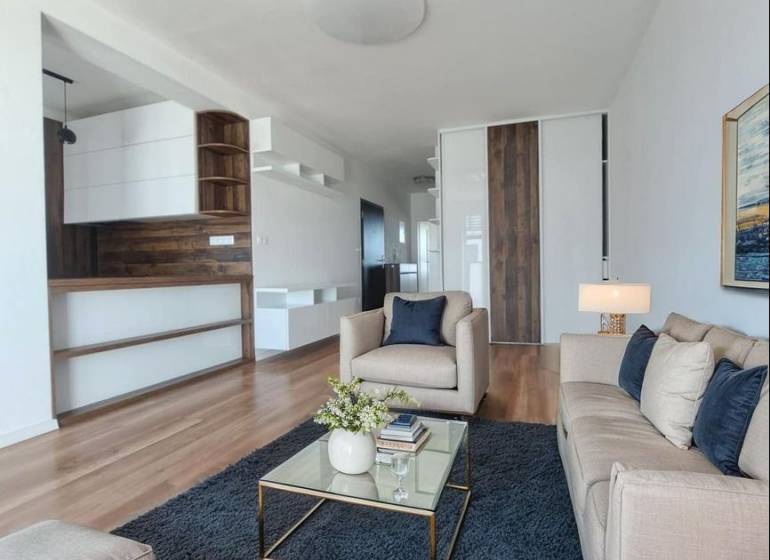 REZERVOVANÝ! Nová cena! Moderný 2-izbový byt – Galanta, sídlisko West - Obývacia izba v 2-izbovom byte s podlahou s dreveným dekorom a pohodlnými sedačkami.