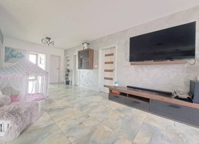 Neodolateľná ponuka! 4-izbová novostavba Galanta-Kolónia za super cenu - Obývačka v Rodinnom dome s televízorom na stene, stanom a keramickou podlahou.