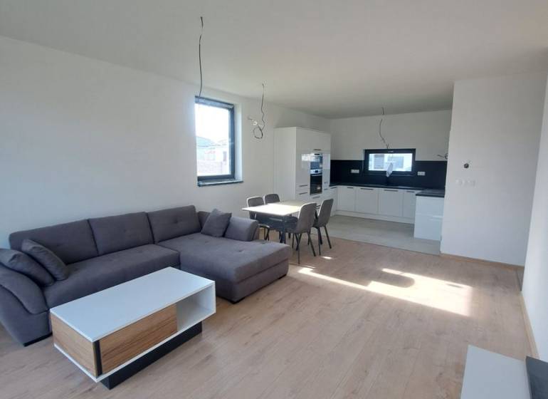 REZERVOVANÉ! Posledná novostavba 4-izbového dvojdomu v štandarde - Obývačka v rodinnom dome s kuchyňou, sedačkou a podlahou s dreveným dekorom.