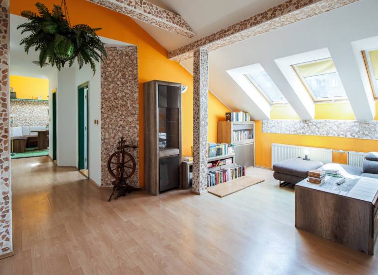 Kúpte si veľký PODKROVNÝ 4i BYT so ZÁHRADOU a PIVNICOU v Starom meste - Podkrovný interiér 4-izbového bytu s drevenou podlahou, knihovňou a svetlými stenami.