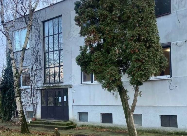  Na predaj  3i byt s vlastnou garážou neďaleko Šale - Exteriér budovy v Seliciach, obklopený stromami a trávnatým prostredím.