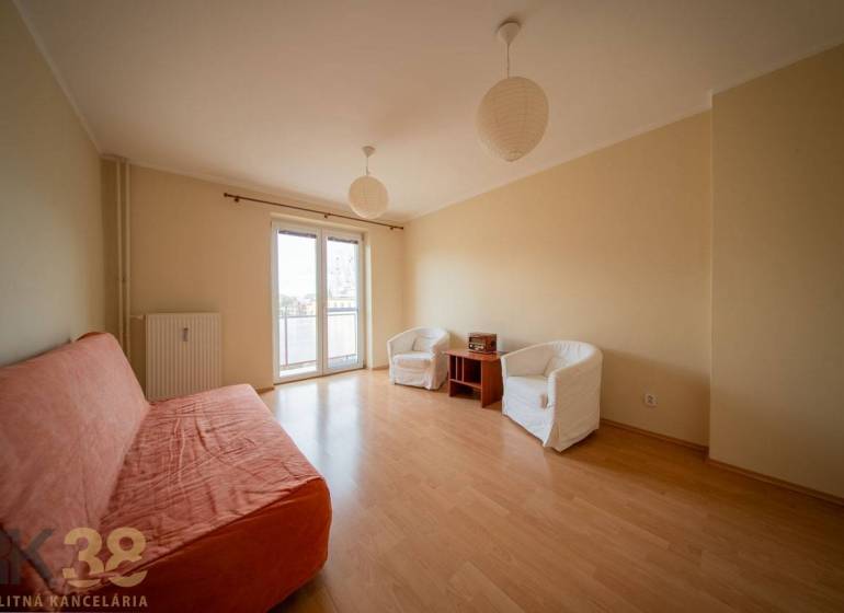 Rezervované: Na predaj pekný 2-izbový byt v centre mesta Poprad - Obývačka v 2-izbovom byte s podlahou s dreveným dekorom, pohovkou a kreslami.