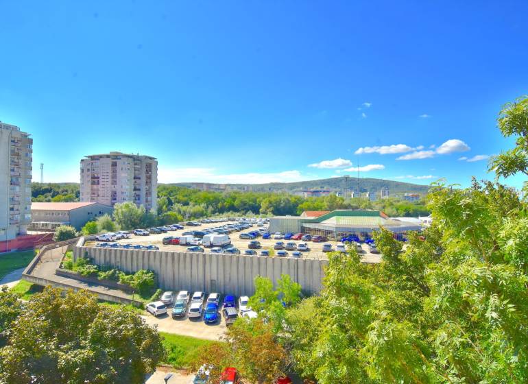 BAKOŠOVA, 1-i byt, 43 m2 – nerušený VÝHĽAD NA KARPATY - Výhľad na parkovisko a okolie v Bratislave - Lamači z Bakošovej, zachytávajúci zeleň a budovy.