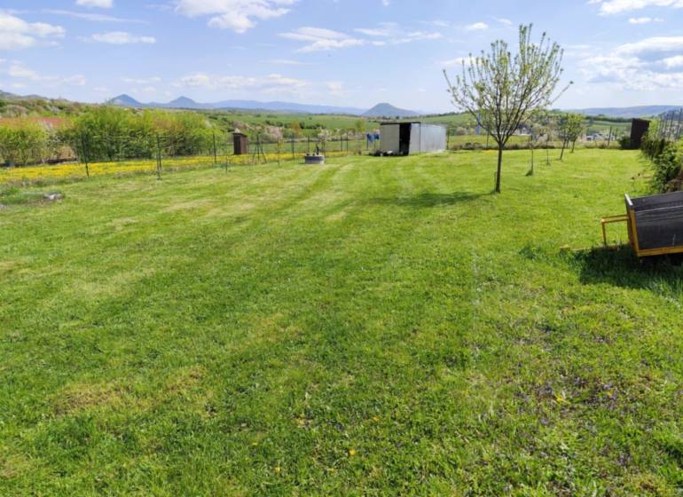 NA PREDAJ PEKNÝ OPLOTENÝ POZEMOK 719m2, SABINOV  - Rozľahlý trávnik s niekoľkými stromami na pozemkoch určených na bývanie v Sabinove.