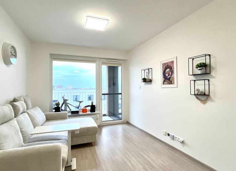 Súčasný 2-izbový byt v novostavbe – Matadorka  - Obývacia izba v dvojgarsónke s podlahou s dreveným dekorom a balkónom.