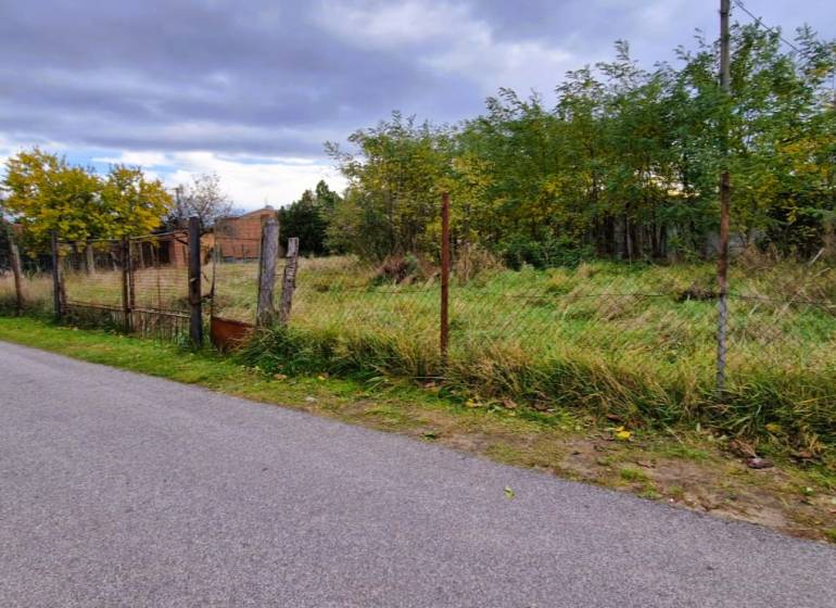 Stavebný pozemok 882 m² | Gajary - Pozemky na bývanie v Gajaroch s viditeľným plotom a okolitými stromami, ponúkajú pokoj.