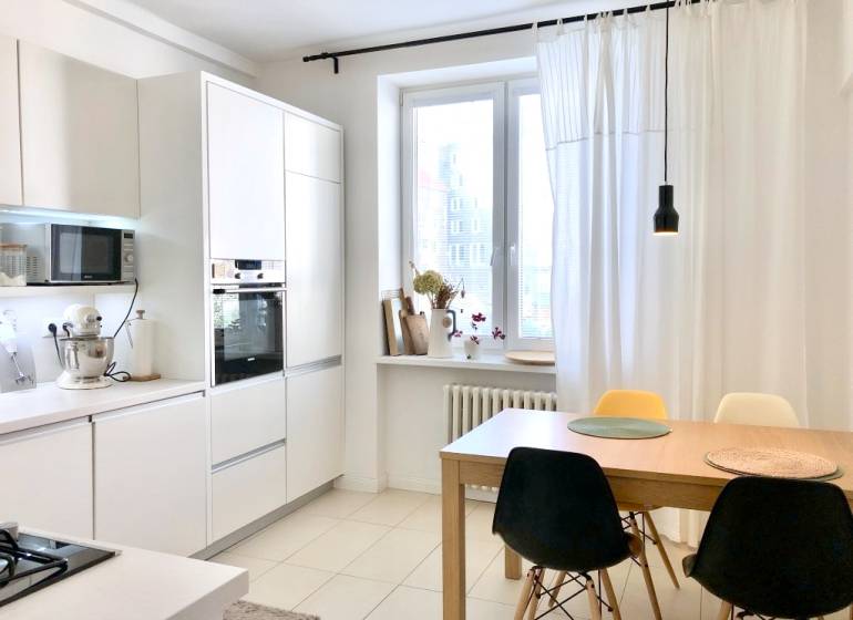 Na prenájom 2 izbový byt, 56 m2, Bratislava, Staré Mesto, Björnsonova - Kuchyňa v 2-izbovom byte s bielymi skrinkami a jedálenským stolom so stoličkami.