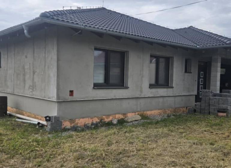 Predaj 4-izbového rodinného domu s veľkou záhradou v Semerove - Rodinný dom z neomietnutých stien v Semerove s šindľovou strechou na trávnatom pozemku.