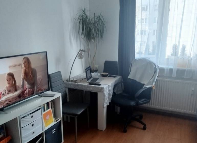PRENÁJOM - zariadena garsónka v Dúbravke. PET FRIENDLY - Garsónka so stolom, stoličkami, knihovničkou a televízorom; podlaha s dreveným dekorom.