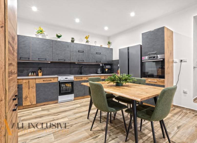 NA PREDAJ 4-IZBOVÝ RODINNÝ DOM V KOLÁROVE - Kuchyňa v rodinnom dome s podlahou s dreveným dekorom a moderným nábytkom.