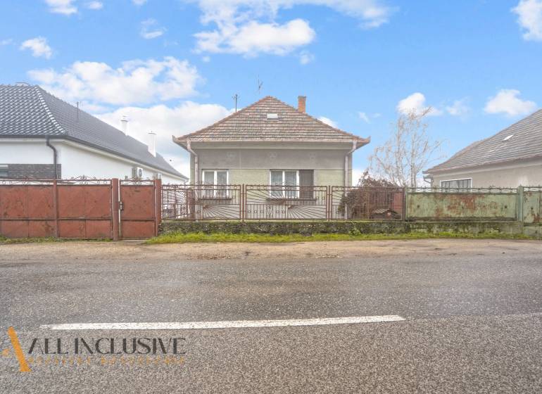 NA PREDAJ 3-IZBOVÝ RODINNÝ DOM VO VEĽKOM BLAHOVE - Rodinný dom v Veľkom Blahove so záhradou a kovovým plotom, iný dom vpravo.