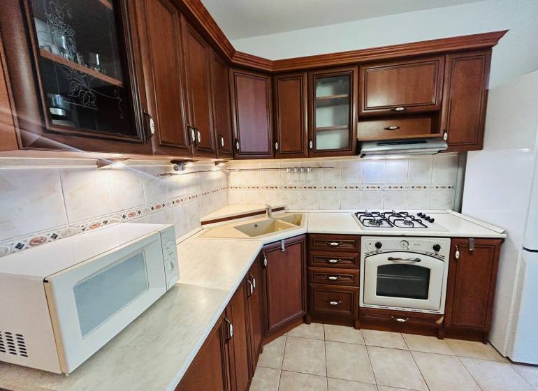 Prenajom 3 izb. bytu na Vajanskeho v NZ - Kuchyňa v 3-izbovom byte s tmavým dreveným dekorom a kachličkami.