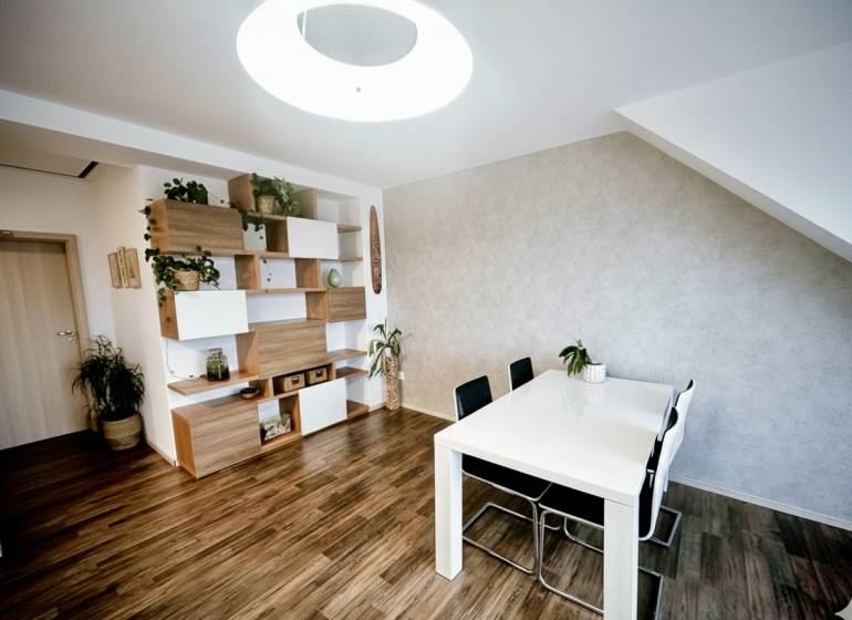 Prenájom moderný a svetlý 3-izbový byt v atraktívnej lokalite - Jedálenský stôl, stoličky a police s dekoračnými prvkami v 3-izbovom byte s podlahou s dreveným dekorom.