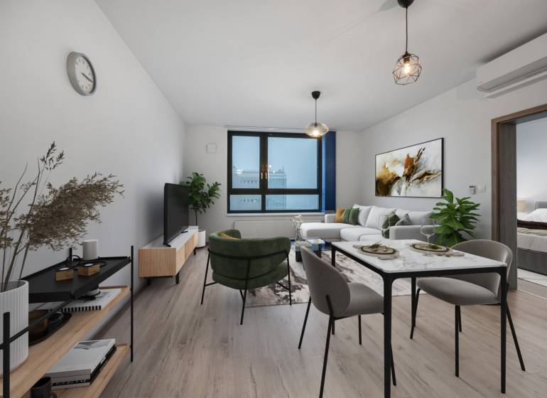 PREDAJ 2-IZBOVÉHO BYTU – NOVOSTAVBA JARABINKY, RUŽINOV - Obývacia izba s pohovkou a jedálenským stolom v 2-izbovom byte, podlaha s dreveným dekorom.