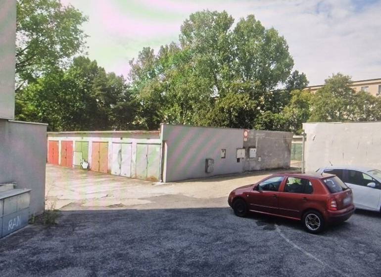 Garáž ul. Planét, Ružinov s pozemkom - Na ulici Planét sú zaparkované autá pred radom farebných garáží, obklopených stromami.