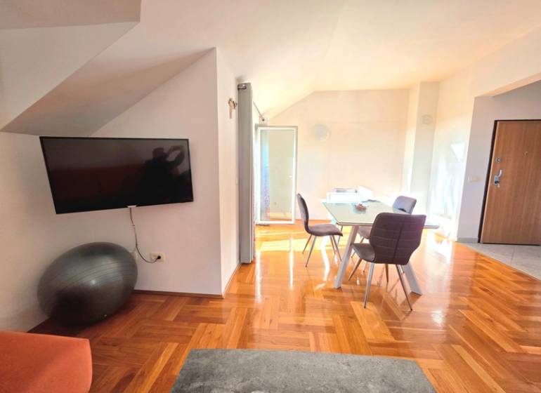 Chorvátsko, Makarska - zariadený apartmán s výhľadom na more - Interiér rekreačného apartmánu s podlahou s dreveným dekorom a jedálenským stolom.