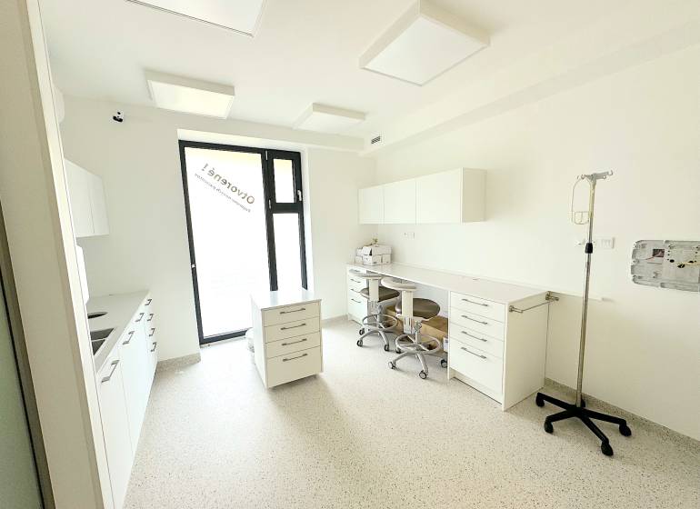 Kompletne zariadená ambulancia, Záhorská Bystrica - Zdravotnícka miestnosť s bielym nábytkom, stoličkami a oknom na Kunovskej ulici.
