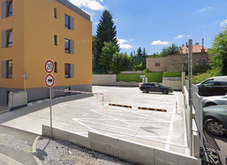 Parkovacie miesto v centre na predaj - Parkovisko a obytná budova na Rudlovskej ceste v Banskej Bystrici obklopené zeleňou.