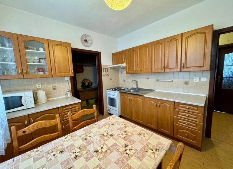 Na prenájom 3,5-izbový byt – Topoľčany, Sídlisko Východ - Kuchyňa s drevenými skrinkami a jedálenským stolom, vhodná pre 3-izbový byt.