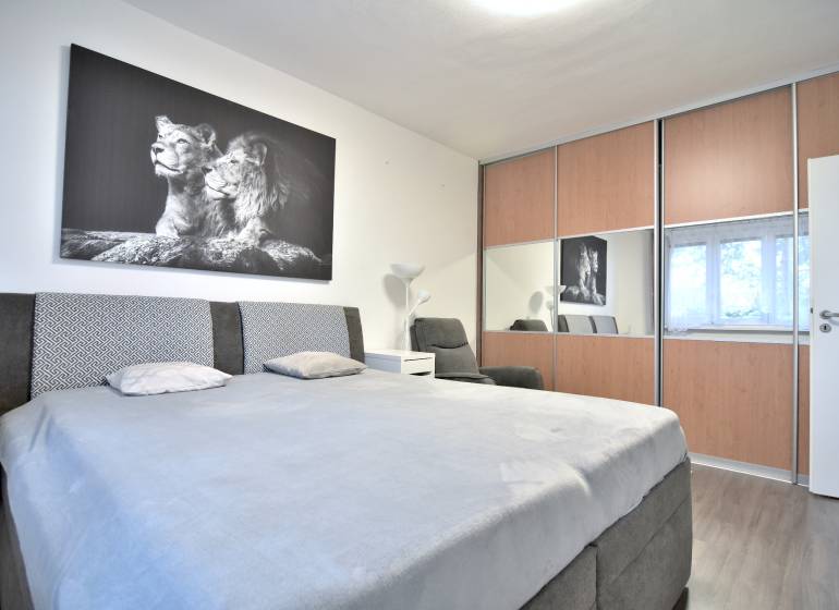 ŠTÚROVA, 3-i byt, 75 m2 – komplet rekonštrukcia, vlastné parkovanie - Spálňa v 3-izbovom byte so šatníkovou skriňou a čiernobielym obrazom levov.