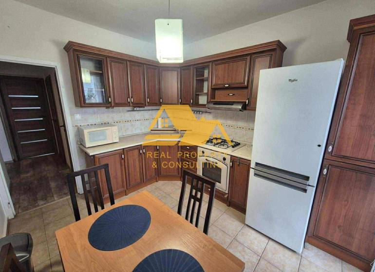 Prenajmem 3 izbový byt s loggiou v Nových Zámkoch - Kuchyňa s tmavým dreveným dekorom, sporákom a chladničkou v 3-izbovom byte.