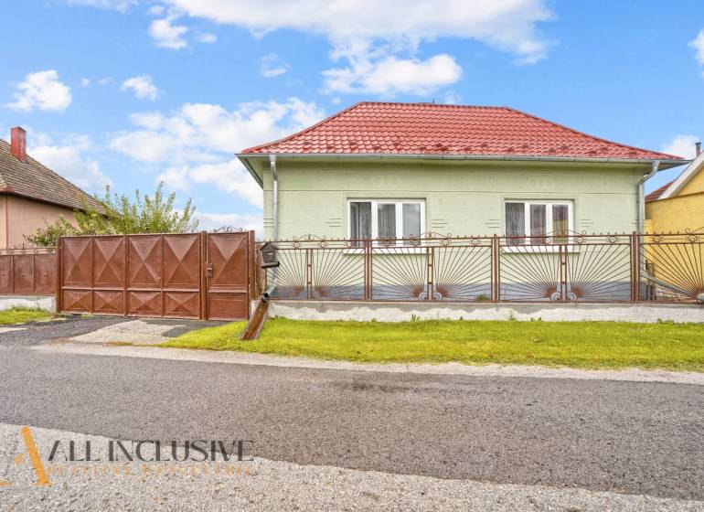 NA PREDAJ 4-IZBOVÝ RD NA VEĽKOM POZEMKU, VRAKÚŇ - Rodinný dom na Nekyje na Ostrove vo Vrakúni s červenou strechou a kovaným plotom.