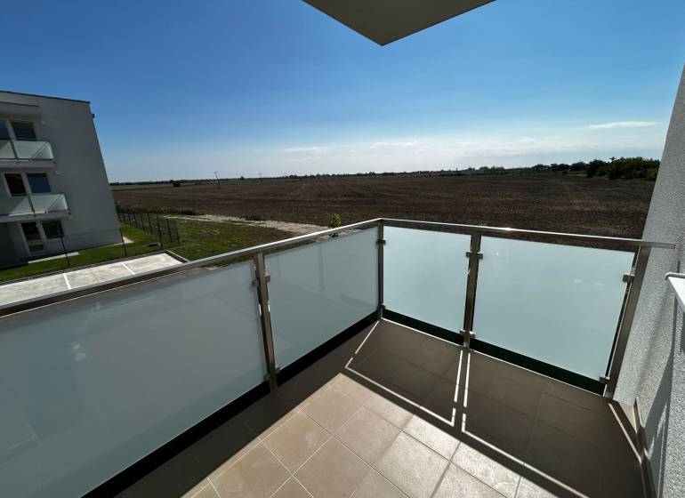 Predaj 3-izbového bytu len 15 minút od Bratislavy  - Balkón 3-izbového bytu na Šamot v Dunajskej Strede s výhľadom na pole.