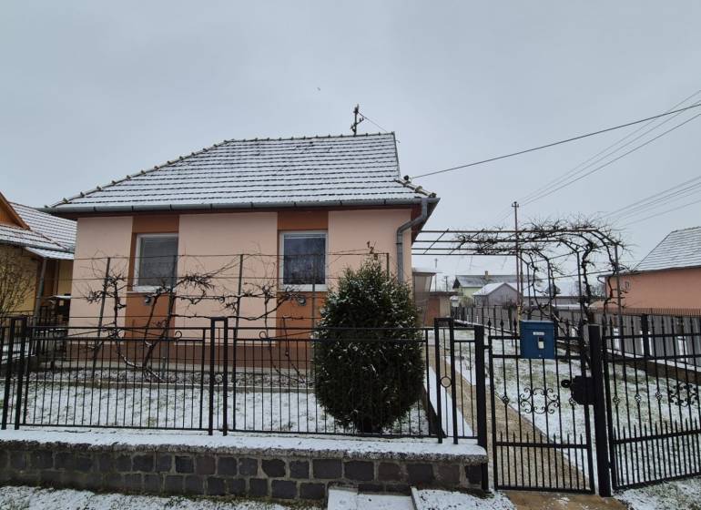 3 IZBOVÝ RODINNÝ DOM S GARÁŽOU, VEĽKÉ OZOROVCE - Rodinný dom na Novej ulici vo Veľkých Ozorovciach so zasneženou strechou a záhradou.