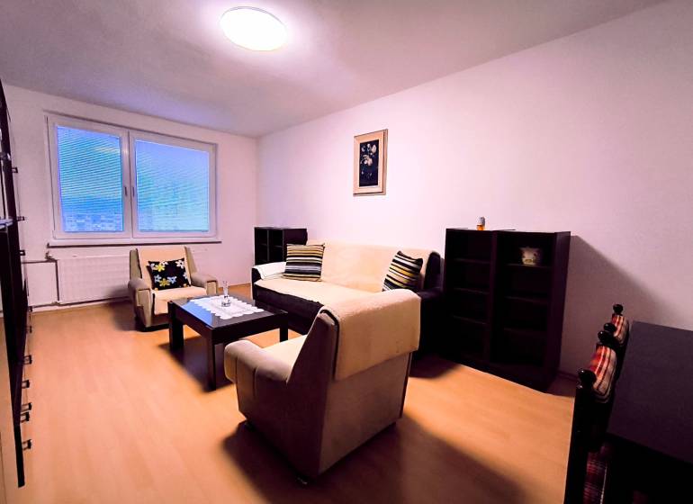 ‼️  PRENÁJOM  - 2 IZBOVÉHO BYTU, PARTIZÁNSKE SÍDLISKO ŠÍPOK ‼️ - Obývačka v 2-izbovom byte s minimalistickým nábytkom a podlahou s dreveným dekorom.