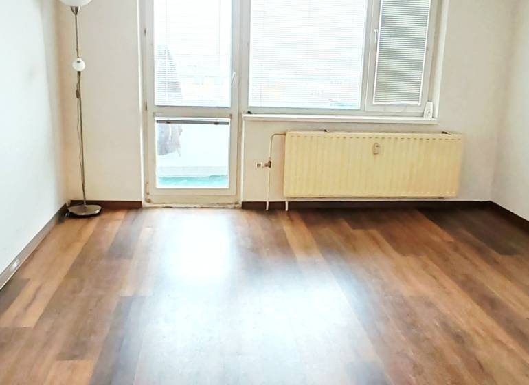 3 izbový byt pri električkovej trati s výhľadom na Draždiak - Podlaha s dreveným dekorom a luster v 3-izbovom byte.