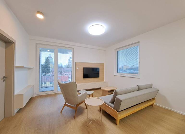 Prenájom: Lukratívny 2-izbový byt v Poprade na Novom nábreží - Obývacia izba v 2-izbovom byte s podlahou s dreveným dekorom, televíziou a výhľadom.