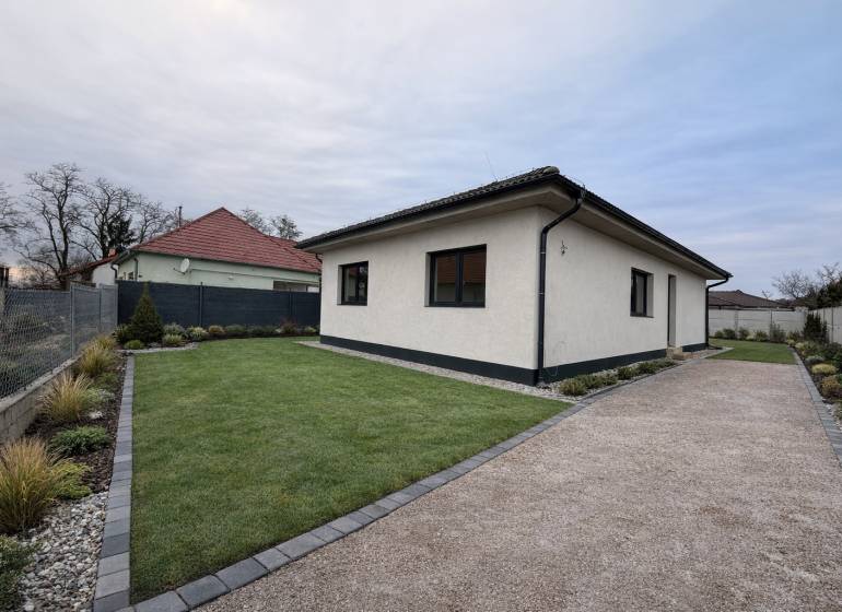 EXKLUZÍVNA SKOLAUDOVANÁ NOVOSTAVBA 4-IZB. RD Z KVALITNÝCH MATERIÁLOV - Rodinný dom vo Veľkom Grobe s trávnikom, štrkovým chodníkom a upravenou záhradou.