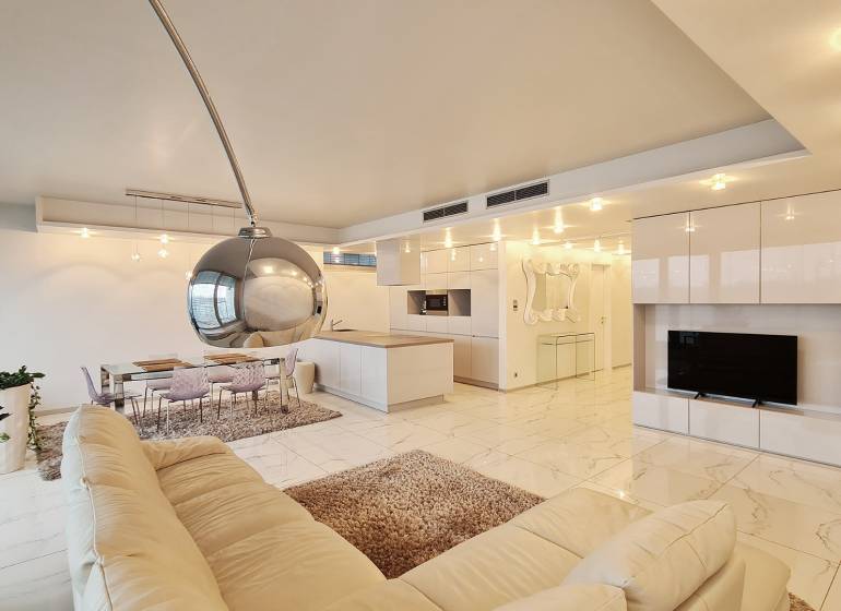 Luxusný 3-izb. byt s famóznym výhľadom na Dunaj, River Park - Interiér 3-izbového bytu s otvorenou kuchyňou, a bielou sedacou súpravou.