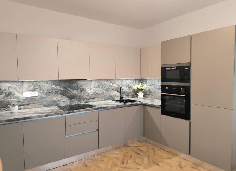 JANOTOVA NOVÝ PO REKONŠTRUKCII EŠTE NEPOUŽÍVANÝ ATYPICKÝ 4 IZB. BYT  - Kuchyňa v 4-izbovom byte s mramorovou pracovnou doskou a podlahou s dreveným dekorom.