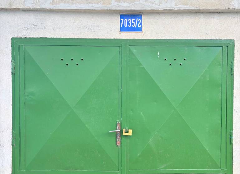 SAMOSTATNÁ GARÁŽ ( 16 m2 ), Gemerská ulica, NIVY, Ružinov - Zelená brána garáže na ulici Gemerská s číslom 7035/2, lemovaná lístím.