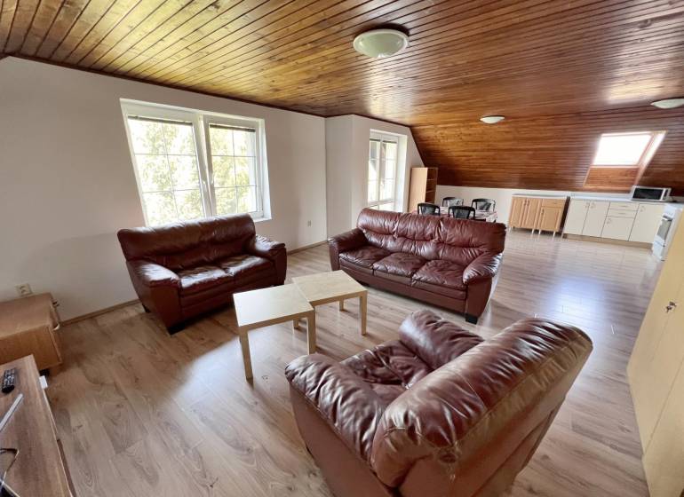 Na prenájom 3i byt v rodinom dome so záhradou - Vojenská ul. Rovinka - Kožené sedačky a drevený strop dopĺňajú priestrannú obývačku, ideálnu pre 3-izbový byt.