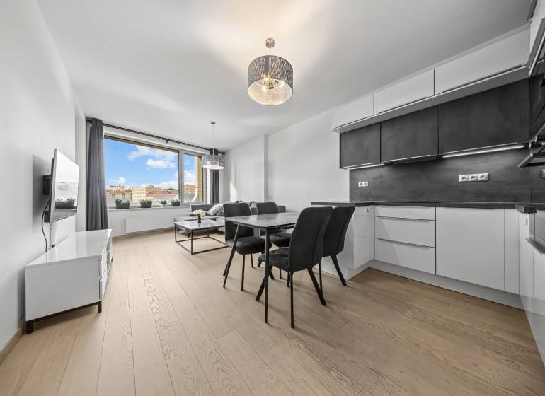 ŠTÝLOVÝ 2i byt,SKY PARK,VÝHĽAD,LOGGIA,PARKING,VEŽA II,Továrenská ul. - Kuchyňa s jedálenským stolom, pohovkou, televízorom a podlahou s dreveným dekorom v 2-izbovom byte.