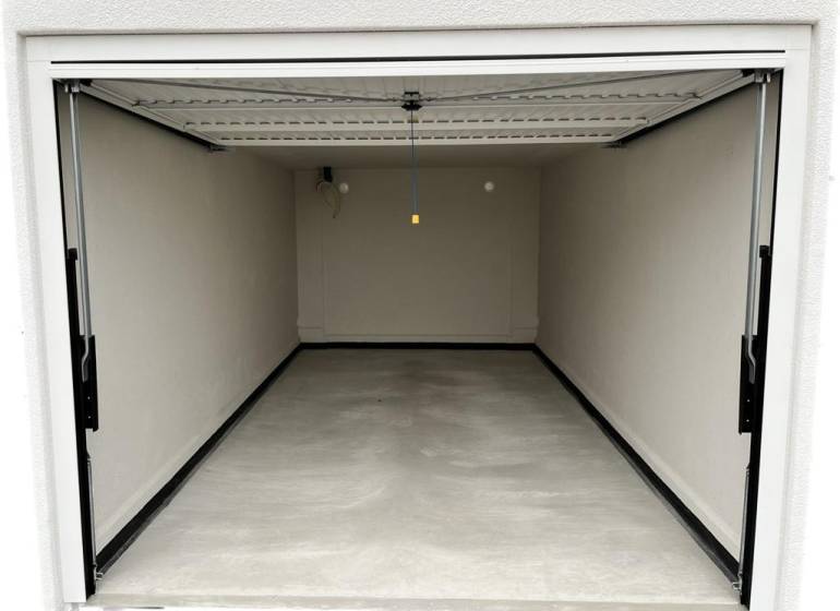 KÚPA POZEMKU NA UMIESTNENIE GARÁŽÍ - Otvorená garáž na ulici Muškátová, ideálne pre komerčné pozemky, prázdny interiér.