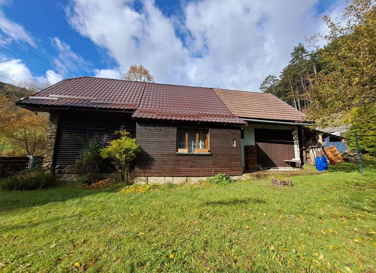 Šikovná drevenica pod lesom Slovenské Pravno  - Rodinný dom v Slovenskom Pravne so šikmou strechou a drevenou fasádou.