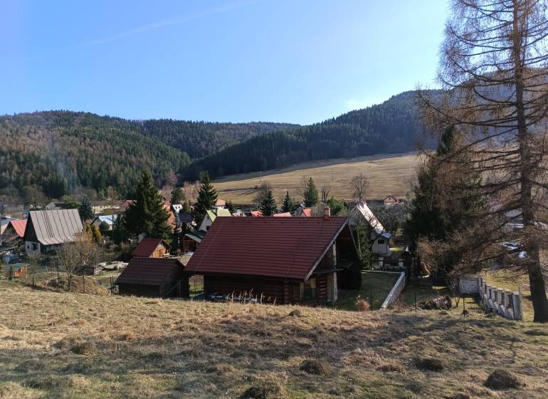 VRÍCKO - Stavebný pozemok vo výmere 1036 m2, okr.Martin - Vidiecka scenéria vo Vrícku so strechami domov a kopcovitým pozadím, Pozemky - bývanie.