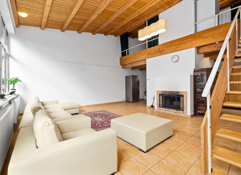 – EXKLUZÍVNE – NA PRENAJOM – DOM – MEDZIERKA – STARÉ MESTO - Obývacia izba v rodinnom dome s krbom, bielou pohovkou a dreveným stropom.