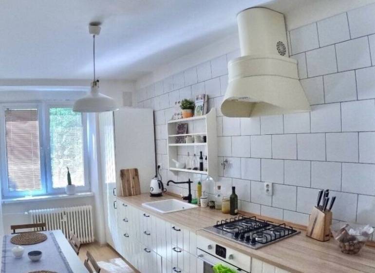 Veľký 2-izb. byt v tehlovom dome, Ružová dolina, Ružinov časť Nivy - Kuchyňa s podlahou s dreveným dekorom a bielym nábytkom v 2-izbovom byte.