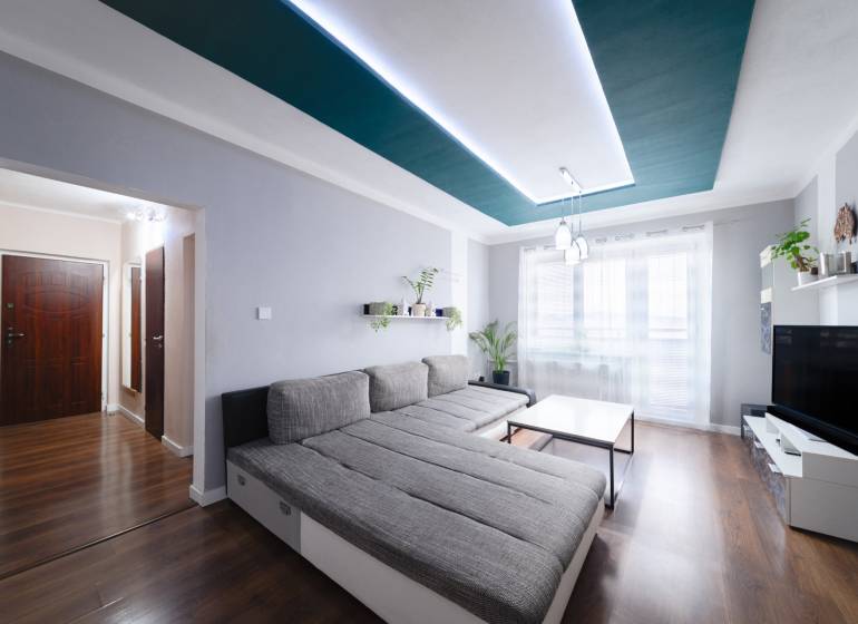 Kompletne zrekonštruovaný 3-izbový byt s balkónom – Rimavská Sobota - Svetlá obývačka v 3-izbovom byte s podlahou s dreveným dekorom a pohodlným sedením.