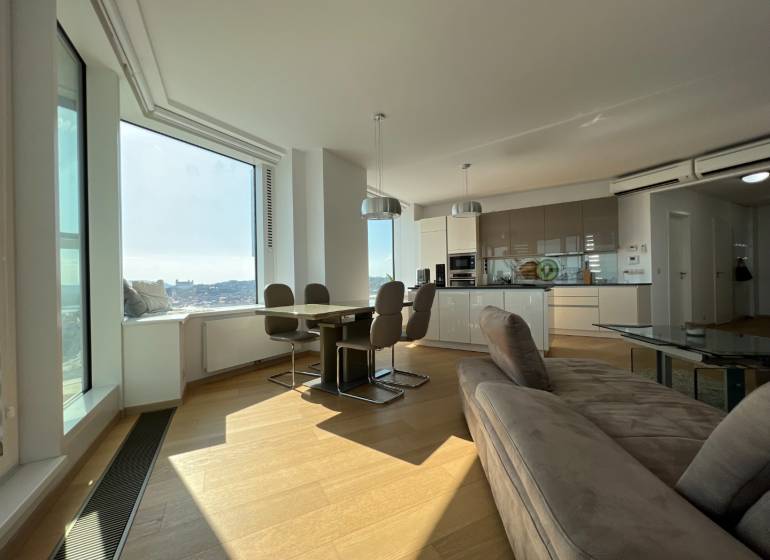 NUERA︱PANORAMA CITY- Veľký 3-izbový byt s výhľadom na hrad - Obývacia izba v 3-izbovom byte s kuchyňou a podlahou s dreveným dekorom.