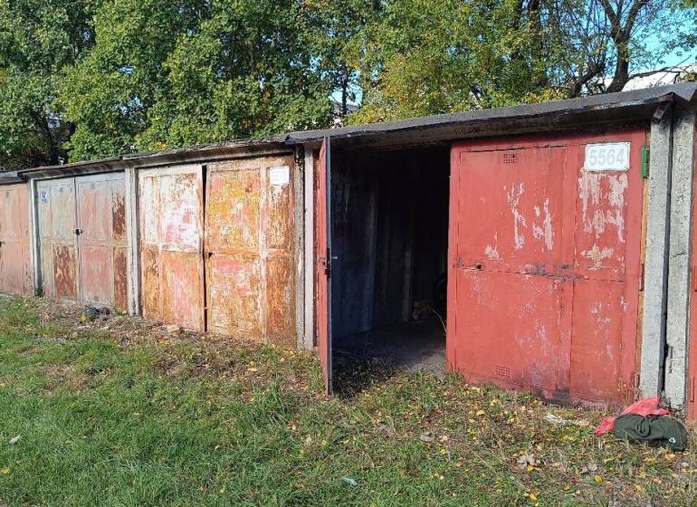 Garáž, Agátova, Dúbravka s pozemkom - Garáže na Agátovej ulici v Bratislave-Dúbravke obklopené zeleňou a lístím.