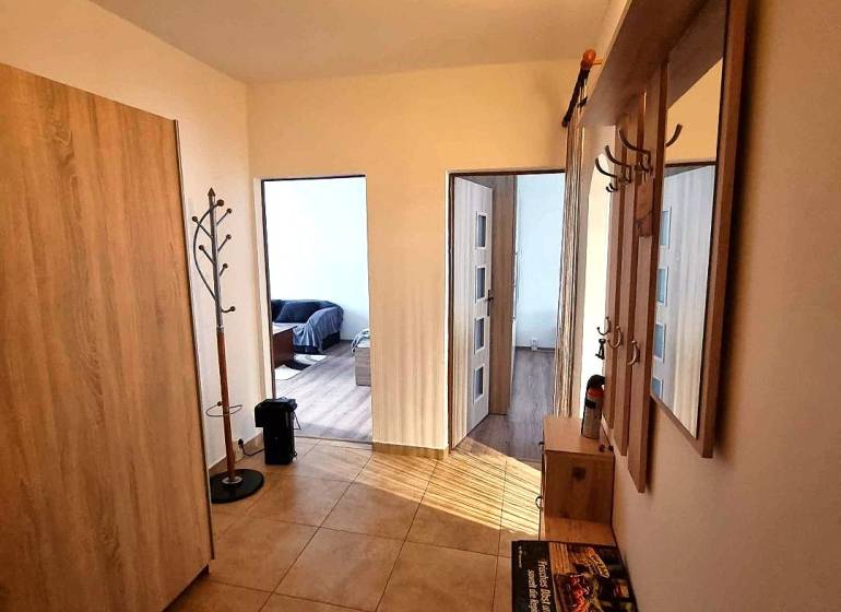 Pekný 2 izbový byt na prenájom - Malacky - Chodba v 2-izbovom byte s vešiakom a podlahou s dreveným dekorom.