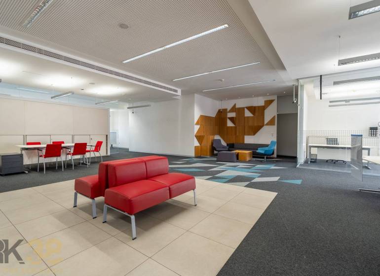 Reprezentatívne administratívne priestory na prenájom  - Kancelárie s červenými sedačkami, konferenčným stolom, vzorovaným kobercom a drevenými dekoráciami.