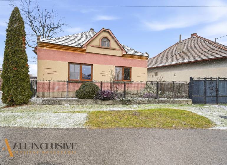 Na predaj 3-izbový rodinný dom, Topoľníky - Rodinný dom v Topoľníkoch s farebnou fasádou, záhradou a zasneženou strechou.