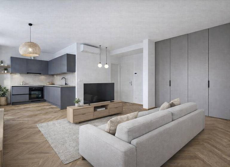 VÝNIMOČNÝ APARTMÁN priamo v centra mesta - projekt UNO Poštová - Kuchyňa v 1-izbovom byte s podlahou s dreveným dekorom a sivými skrinkami.